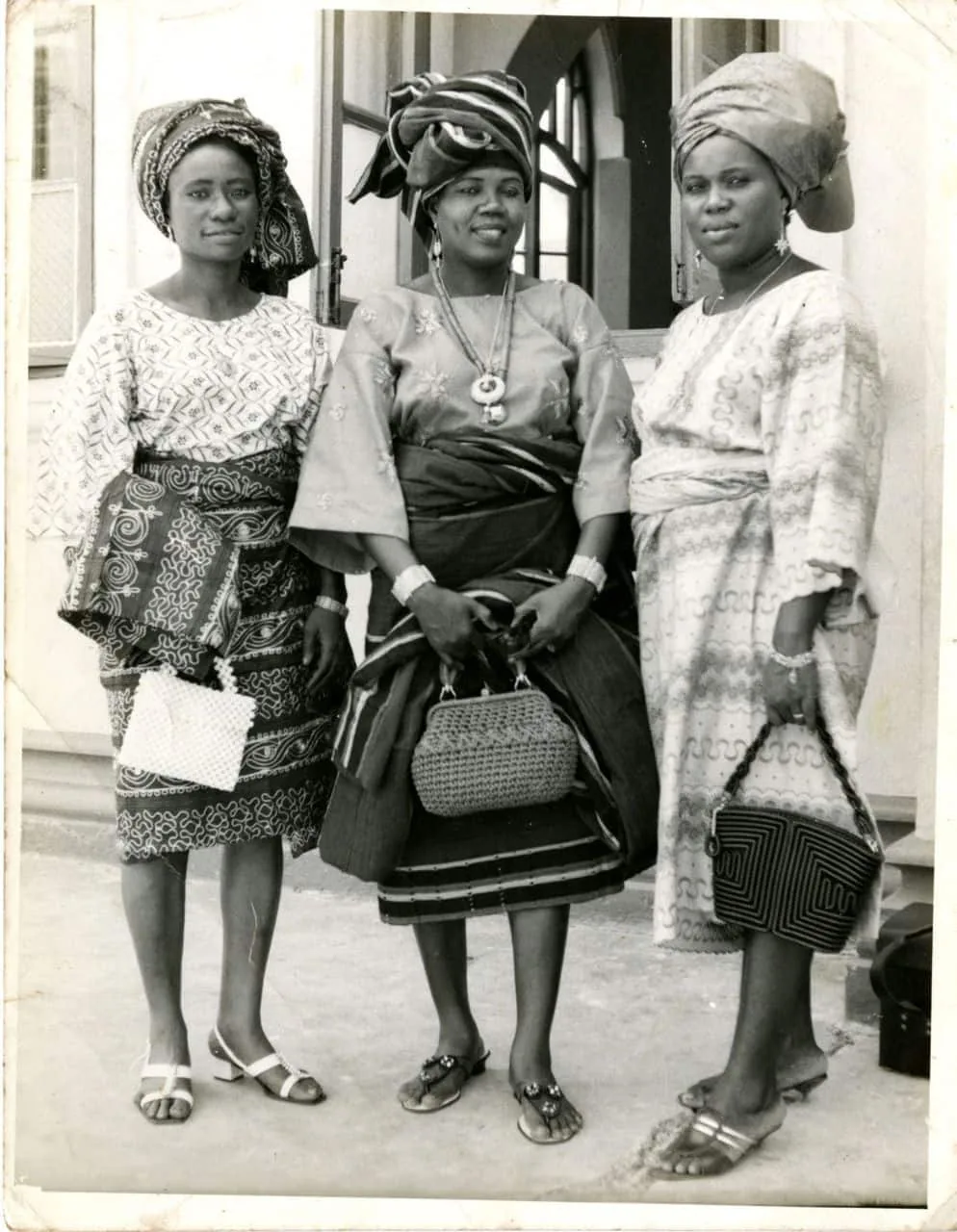 Three Nigerian women in gele and wrappers