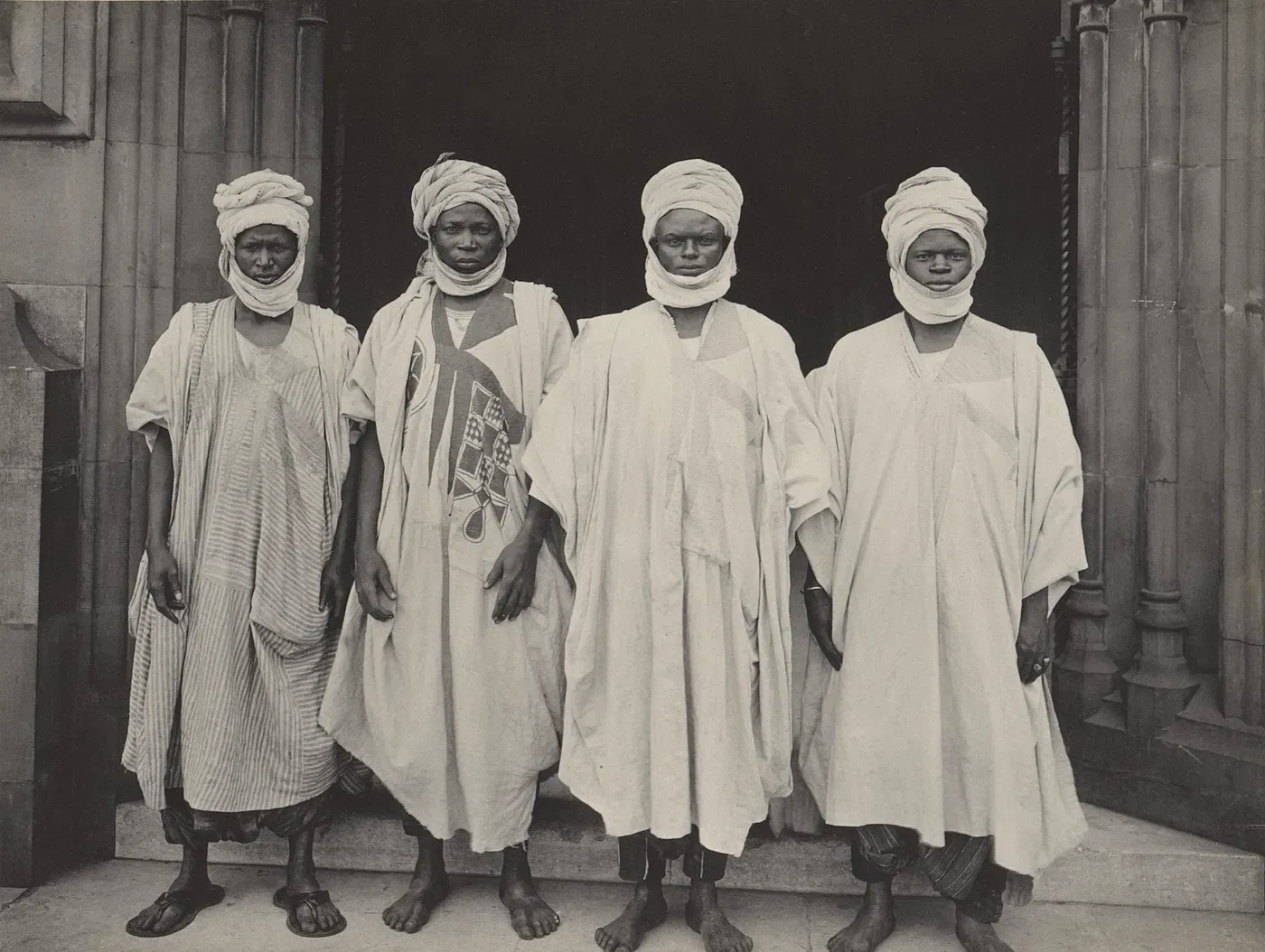 Four men in traditional northern Nigerian robes and turbans