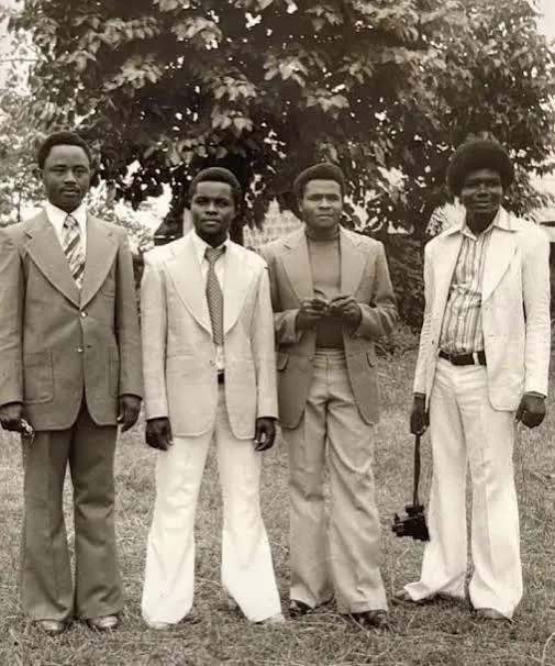 Four young men in 1970s flared suits